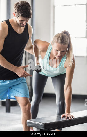 Sporty woman using dumbbells with personal trainor Stock Photo