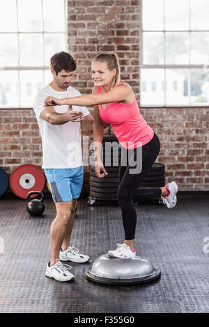 Woman doing exercises on a bossu ball Stock Photo