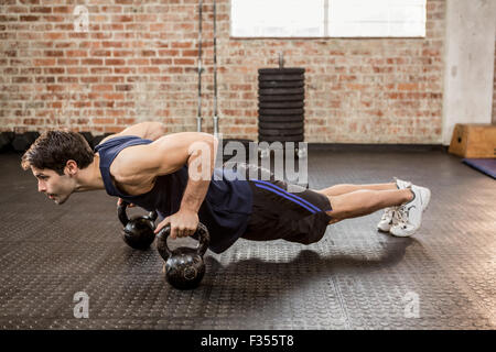 Man doing push ups with kettlebell Stock Photo