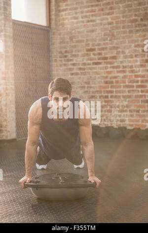 Man doing bosu push ups Stock Photo