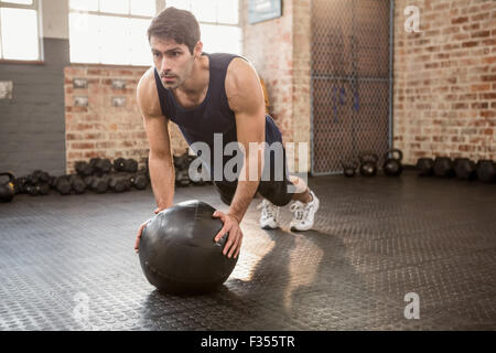 Man doing push ups on medicine ball Stock Photo