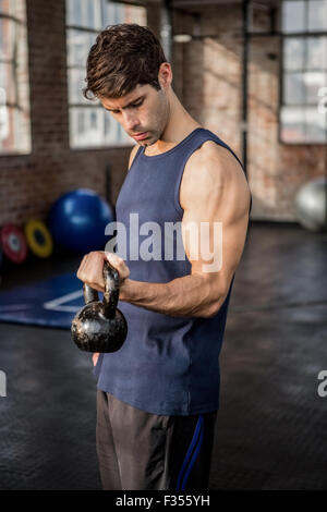 Side view of a man lifting kettlebell Stock Photo