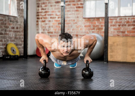 Portrait of man doing push ups with kettlebell Stock Photo
