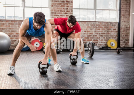 Men doing exercise with kettlebell Stock Photo