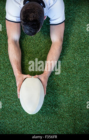 High angle view of man holding rugby ball with both hands Stock Photo