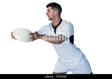 Rugby player leaning over while holding the ball Stock Photo