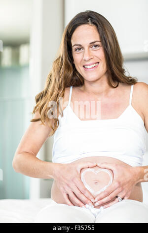 Portrait of happy woman with heart on belly Stock Photo