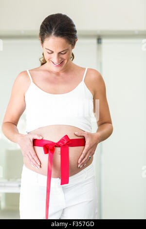 Happy woman looking down on red ribbon Stock Photo