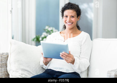 Portrait of happy woman using tablet on sofa Stock Photo