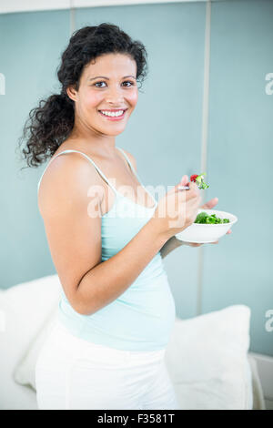 Pregnant woman holding bowl of salad Stock Photo