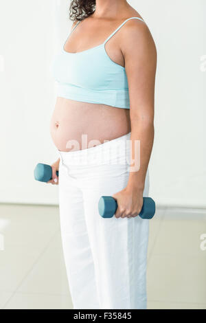 Pregnant woman lifting weights Stock Photo