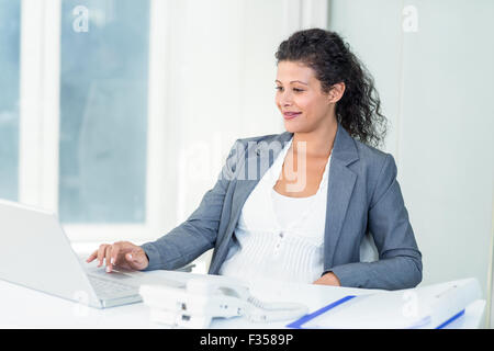 Pregnant businesswoman working on computer Stock Photo