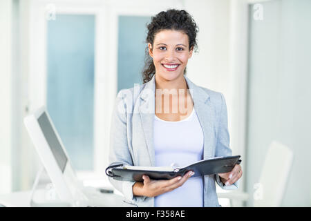 Smiling beautiful businesswoman holding document Stock Photo