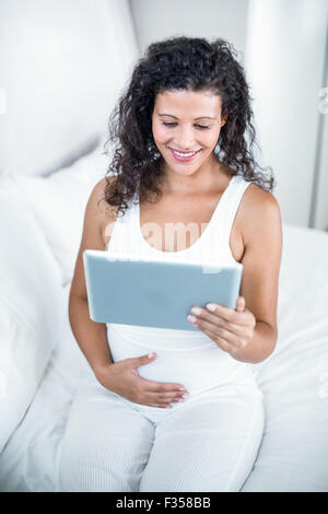 Attractive pregnant woman using digital tablet Stock Photo