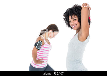 Woman stretching while female friend exercising Stock Photo