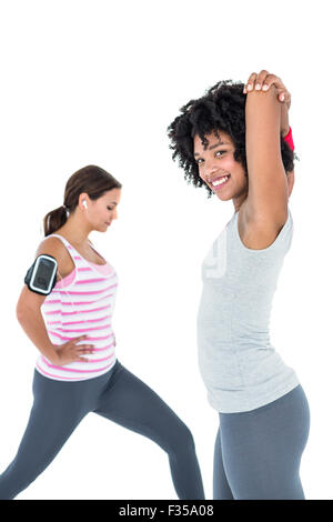 Woman exercising while female friend stretching Stock Photo