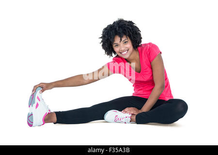 Portrait of young woman touching toes while exercising Stock Photo