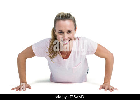 Portrait of happy fit woman doing push ups Stock Photo
