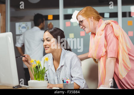 Smiling businesswomen using computer in office Stock Photo
