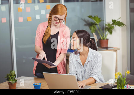 Businesswomen using technologies in office Stock Photo