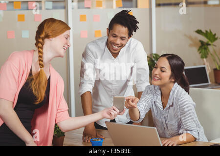 Businesswoman showing smartphone in office Stock Photo
