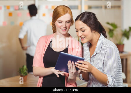 Smiling businesswomen using digital tablet in office Stock Photo