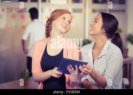 Happy businesswomen using digital tablet in office Stock Photo