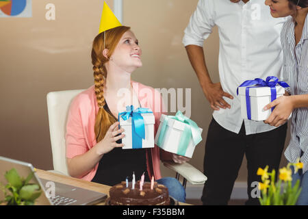 Smiling businesswoman receiving birthday gifts Stock Photo