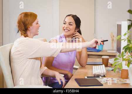 Businesswoman showing something on computer to happy colleague Stock Photo