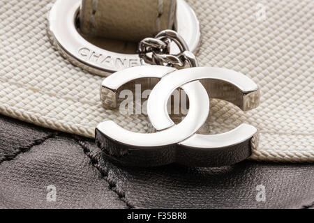 Close up of metal name tag on a Chanel designer brand name tag. Interlinked CC the logo of Chanel attached to side of bag. Stock Photo