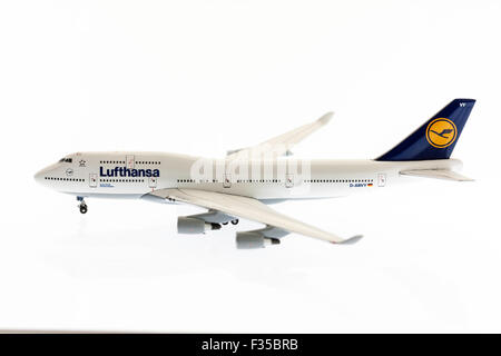 Close up of a die-cast 1/200 scale model of Lufthansa Boeing 747 jumbo jet on plain white background with some underlighting. Stock Photo