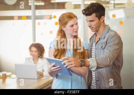 Businesswoman showing digital PC to businessman Stock Photo