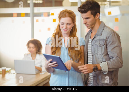 Businesswoman showing digital PC to businessman Stock Photo