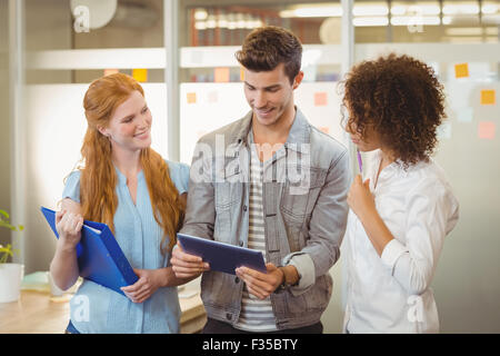 Businessman using digital table with female colleagues Stock Photo