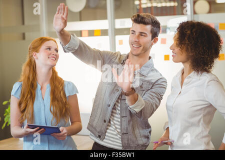 Businessman gesturing while female colleagues looking at him Stock Photo