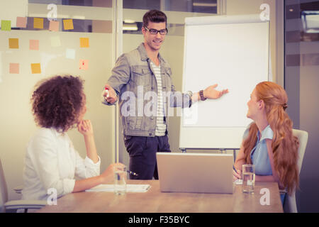 Businessman explaining female colleagues Stock Photo