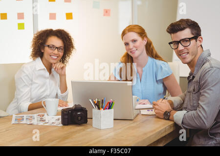 Colleagues using laptop during meeting with businesswoman Stock Photo