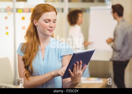 Confident businesswoman using digital tablet with colleagues Stock Photo