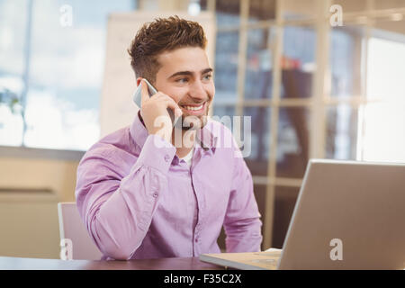 Businessman calling on phone in office Stock Photo
