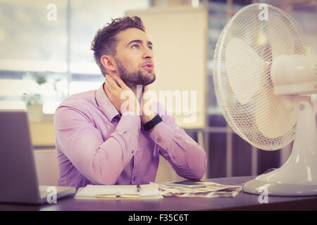 Businessman looking up while sitting at desk Stock Photo