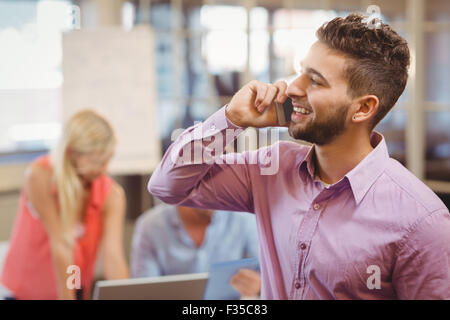 Businessman talking on phone in office Stock Photo