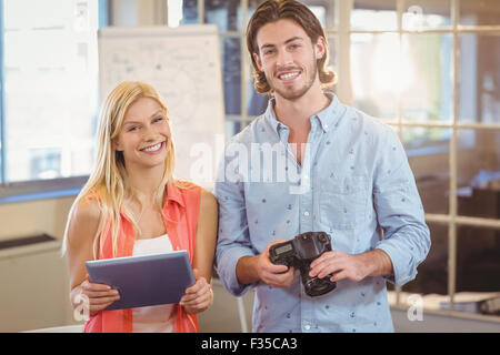 Business people holding camera and digital tablet Stock Photo
