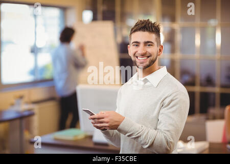 Portrait of smiling businessman texting on phone Stock Photo