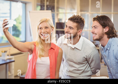 Businesswoman taking selfie with male colleagues Stock Photo