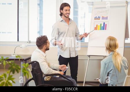 Businessman giving presentation to colleagues Stock Photo