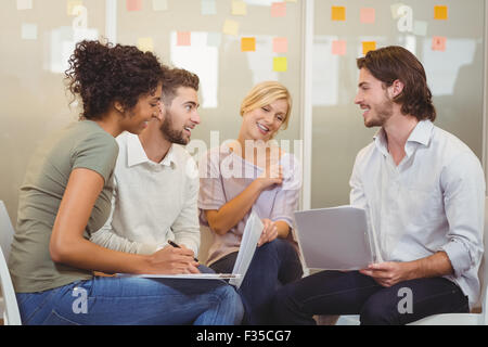 Colleagues looking at businessman Stock Photo