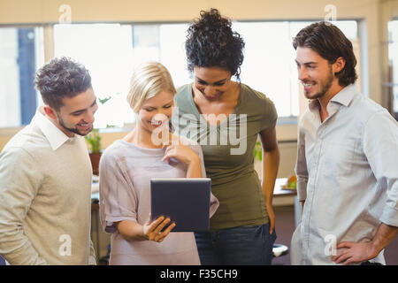 Smiling colleagues using digital tablet in office Stock Photo