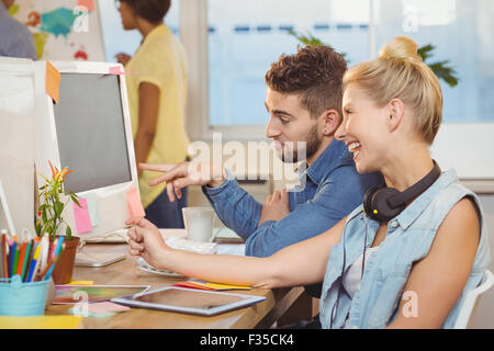 Happy business people looking at computer Stock Photo