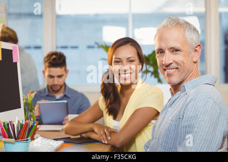 Smiling business people working in creative office with employees Stock Photo