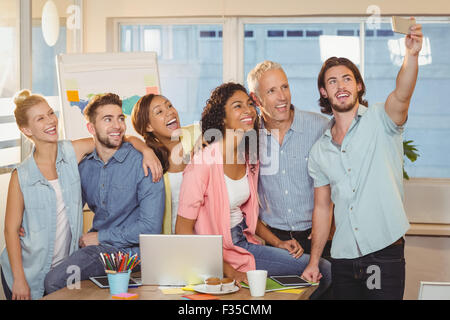 Businessman taking selfie of colleagues in meeting room Stock Photo